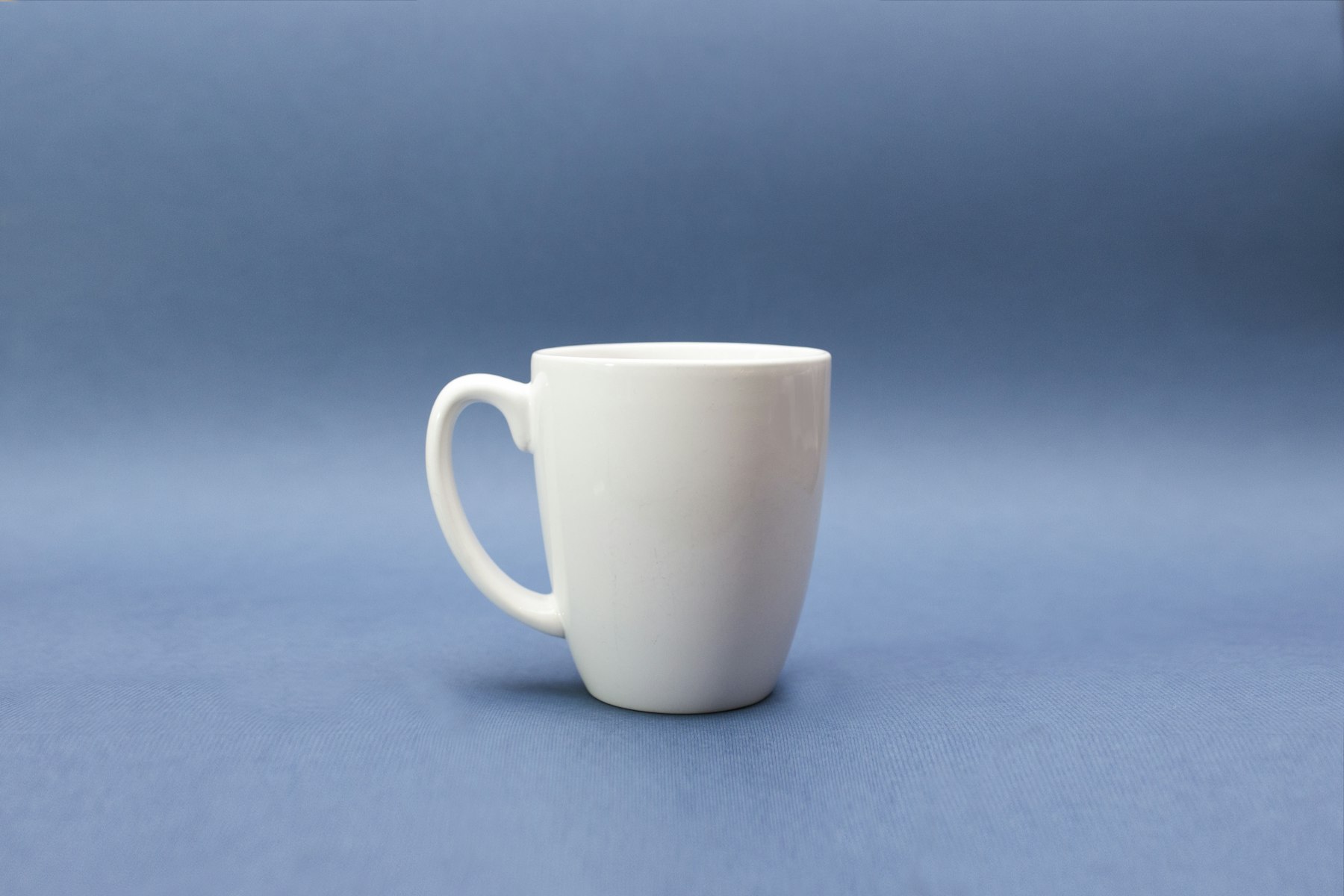 Cană albă de ceramică pe fundal albastru