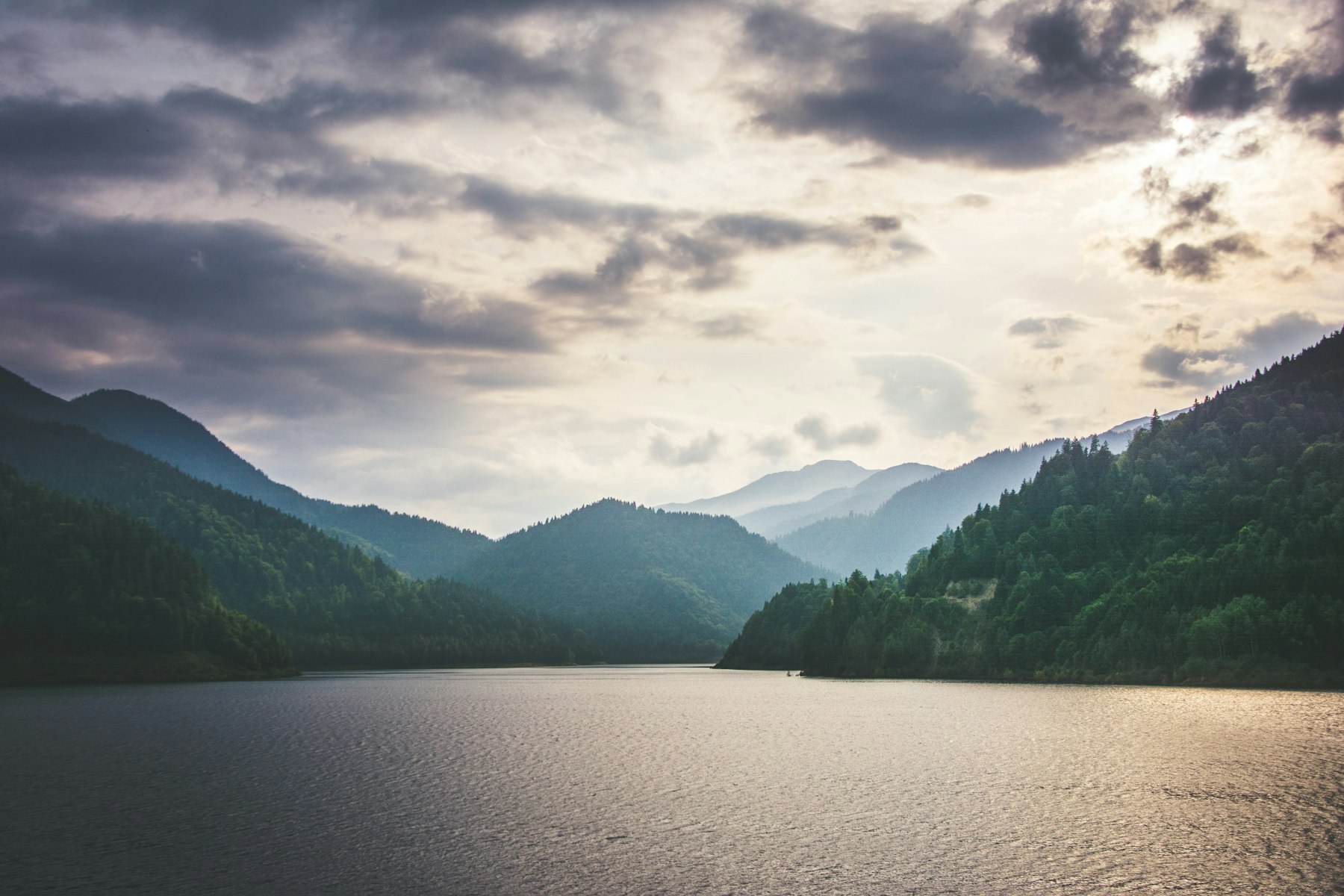 Lac de munte, între dealuri împădurite