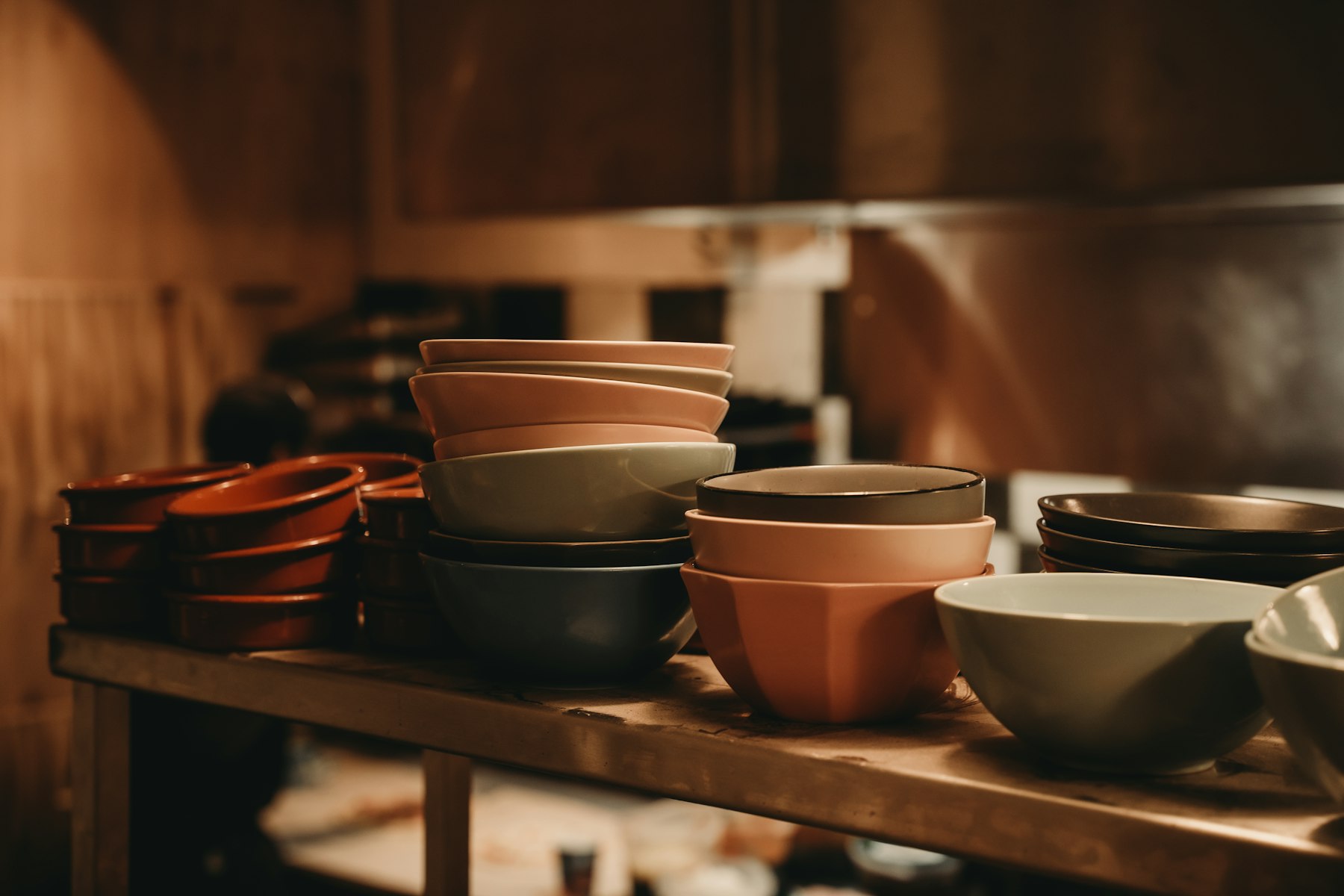 Boluri de ceramică stivuite pe un raft de lemn, în atelier